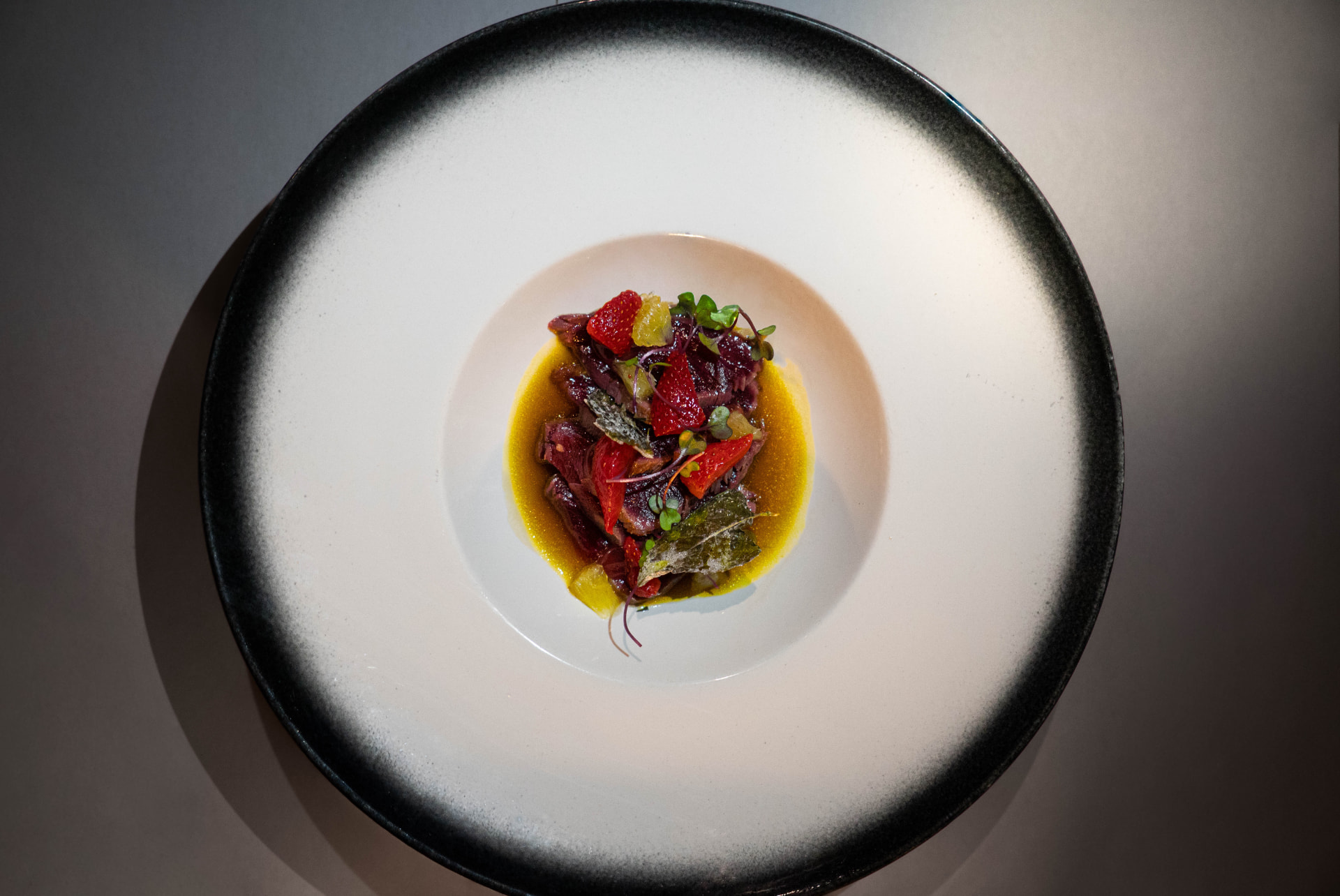 Tartare servi dans une assiette noire et blanche