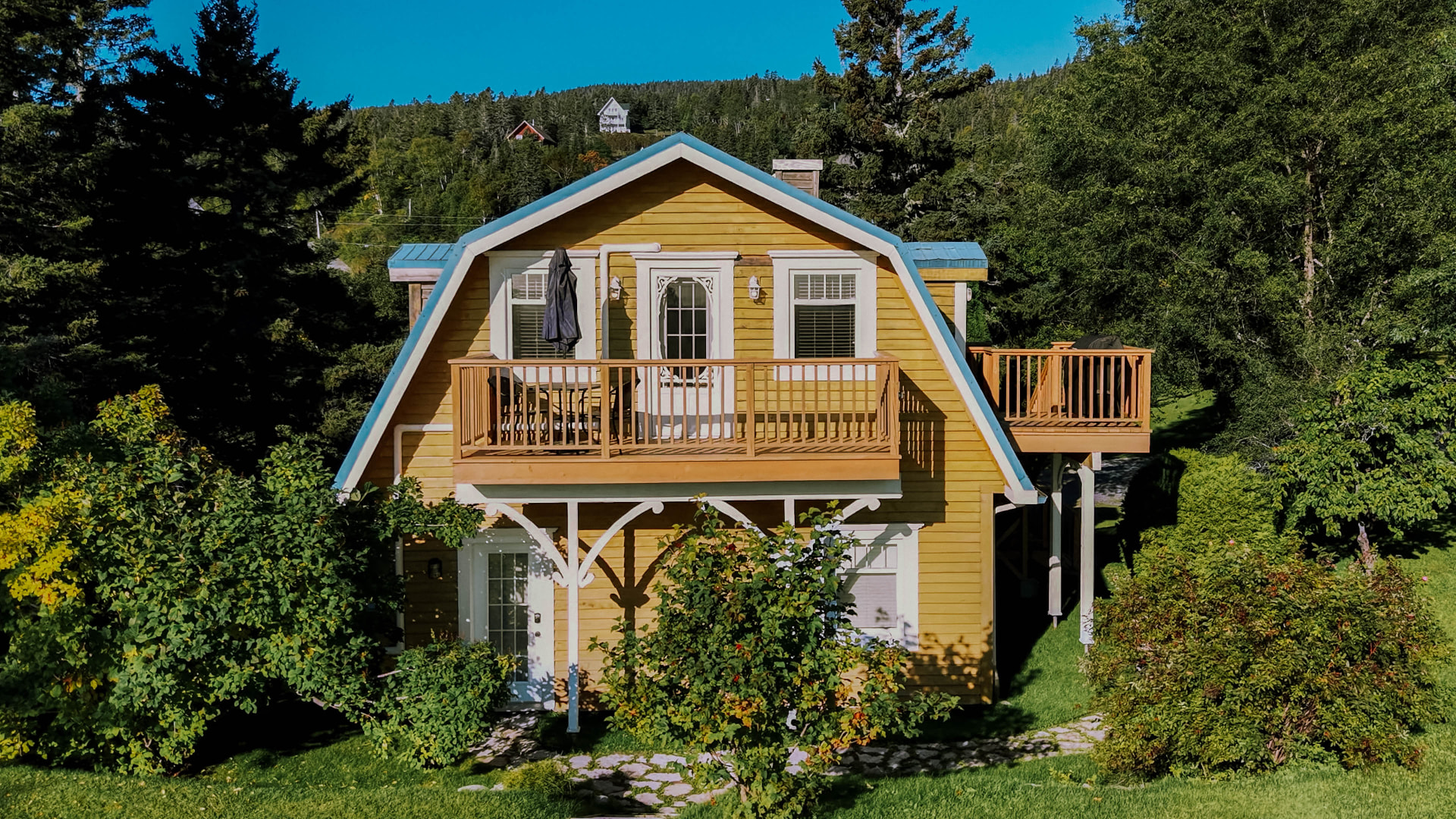 Façade du chalet avec balcon et toit de métal bleu